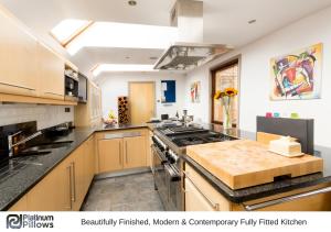 a large kitchen with a stove and a counter top at Cherwell Gates 4 Bed Luxury Oxford Apartment for 8 with Roof terrace in Oxford