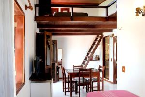 a room with a dining table and a loft bed at Hotel e Pousada La Dolce Vita in Canoa Quebrada