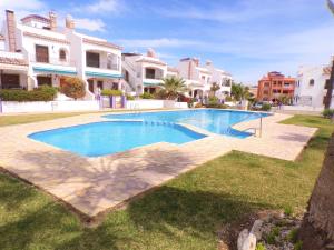 a swimming pool in the middle of a yard with houses at Villamartin Violetas holiday home in Villamartin