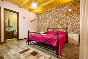 a bedroom with a bed and a stone wall at Stella marina in Castellammare del Golfo