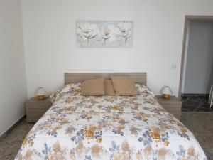 a bedroom with a bed with a flower picture on the wall at Jolandahome in Massa Lubrense