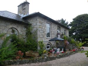 a stone house with an umbrella in front of it at Disblair House in Newmacher