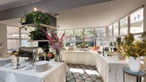 a restaurant with white tables with flowers on them at Hotel Lombardia in Milan