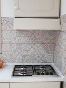 La cocina está equipada con fogones y azulejos. en Jolandahome en Massa Lubrense