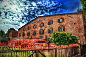 a brick building with a fence in front of it at Karczma Rycerska Lebork in Lębork