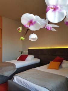 two beds in a hotel room with flowers on the ceiling at Hotel Boavista in Timişoara