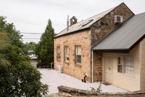 an old brick building with a garage next to it at Clare Valley Heritage Retreat in Clare