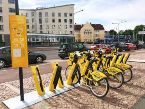 a row of yellow bikes parked next to a street at Roost Roobert 3 in Helsinki