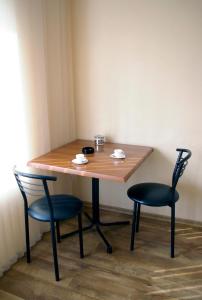 une table en bois avec deux chaises et une table avec deux tasses dans l'établissement Apartment on Sobornyi Avenue, à Zaporijia