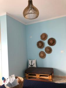 um quarto com uma parede azul com um repousa-pés e cestos em Casa Natali em Durrës