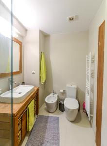 a bathroom with a sink and a toilet and a mirror at Spacious Fully Equipped 3BD 2Bath Apt in the heart of city with Balconies AC and fast WIFI #2 in Heraklio Town