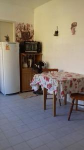 Apartamento kitchenette في ساو لورينسو دو سول: مطبخ مع طاولة وثلاجة بيضاء