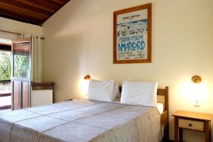 um quarto com uma cama e um cartaz na parede em Hotel e Pousada La Dolce Vita em Canoa Quebrada