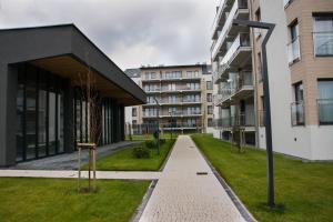 a building with a tree in the middle of a street at Apartament 5Mórz Leo in Sianozety