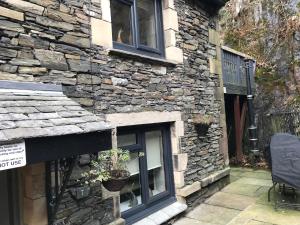 a stone building with a window on the side of it at Honeypot Cottage in Centre of Bowness in Bowness-on-Windermere