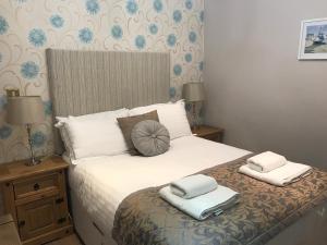 1 dormitorio con 1 cama con 2 almohadas en Honeypot Cottage in Centre of Bowness, en Bowness-on-Windermere