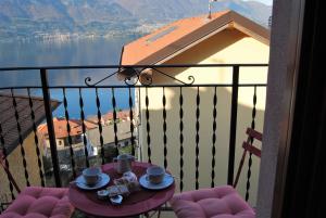 une table avec des tasses et des soucoupes sur un balcon dans l'établissement Casa da Giorgia, à Lezzeno