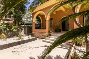 a house with palm trees in front of it at Aloe Apartments in Corfu