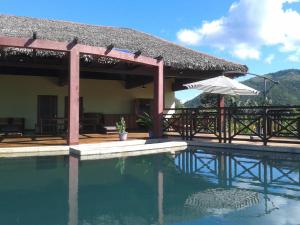 a house with a swimming pool and an umbrella at Zara Village in Nosy Be