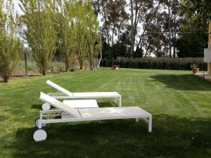 two white chairs sitting on the grass in a yard at Villa la casa di Siro in Bracciano +77 photos