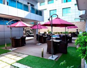 a patio with tables and chairs with pink umbrellas at Seasons hotel and spa in Nampula