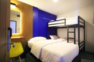 two bunk beds in a room with a blue wall at Tuk Tuk Hostel in Bangkok