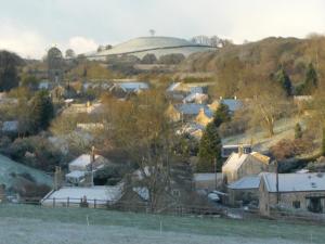 a small village with a hill in the background at Whidlecombe Farm in Priston