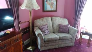 a living room with a chair and a lamp at Disblair House in Newmacher