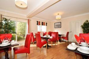 a dining room with red chairs and tables at Lynfield B&B in Galway