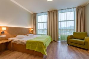 1 dormitorio con 1 cama, 1 silla y ventanas en Go Hotel Shnelli en Tallin