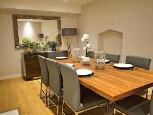 een eetkamer met een houten tafel en stoelen bij The Norfolk Townhouse - Stunning 5BDR Home in Londen