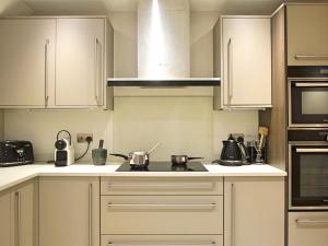 een keuken met witte kasten en een fornuis met oven bij The Norfolk Townhouse - Stunning 5BDR Home in Londen