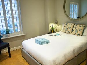 een slaapkamer met een groot bed en een spiegel bij The Norfolk Townhouse - Stunning 5BDR Home in Londen