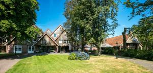 une grande maison avec une statue en face de celle-ci dans l'établissement Fletcher Hotel-Restaurant De Broeierd-Enschede, à Enschede