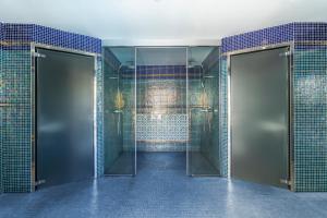 a bathroom with two doors and blue tiles at Essence Hotel Boutique in Torremolinos