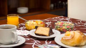Hotel 15 de Mayo في فيلا كارلوس باز: طاولة مليئة بأطباق الطعام وكوب من القهوة