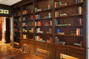 a library with wooden shelves filled with books at Fletcher Hotel-Restaurant De Broeierd-Enschede in Enschede