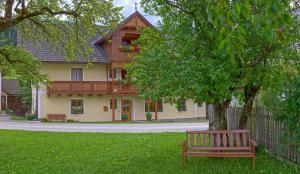 um banco de parque sentado em frente a uma casa em Moserhof em Haus im Ennstal