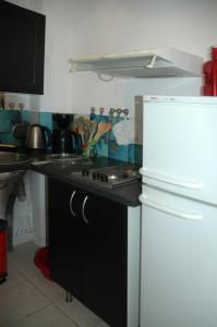 a kitchen with a stove and a white refrigerator at Studios "Villa Coeur sur Mer" in La Croix-Valmer