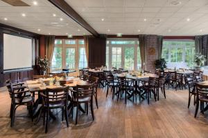 une salle à manger avec des tables et des chaises en bois dans l'établissement Fletcher Hotel-Restaurant De Broeierd-Enschede, à Enschede