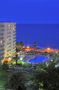 a large pool in a park at night at Sol Puerto Marina in Torremolinos