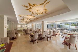 a dining room with tables and chairs and a chandelier at Essence Hotel Boutique in Torremolinos