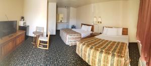 a hotel room with two beds and a flat screen tv at Mountain View Inn Yreka CA in Yreka