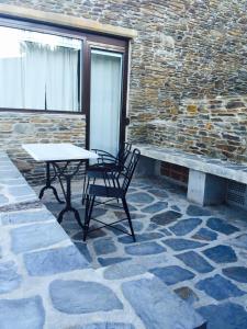 two chairs and a table on a stone patio at Es volca in Cadaqués
