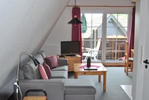 ein Wohnzimmer mit einem Sofa und einem TV in der Unterkunft Ferienwohnungen Stricker Harz in Walkenried