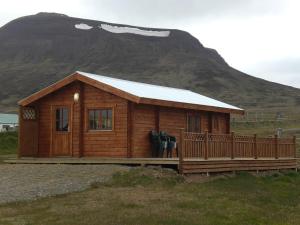 a small wooden cabin with a mountain in the background at Steinnýjarstaðir in Skagaströnd