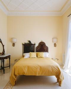 a bedroom with a large bed with yellow sheets at Dimora Archimedea in Syracuse