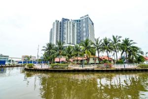 a city with tall buildings and palm trees and a river at The Shore Walking To Jonker Streets 5 in Melaka