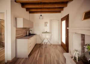 LongareにあるCasa Bassettoの白いキャビネットと暖炉付きのキッチン