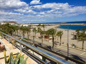 a view of a beach with palm trees and the ocean at El Ático de Carboneras in Carboneras